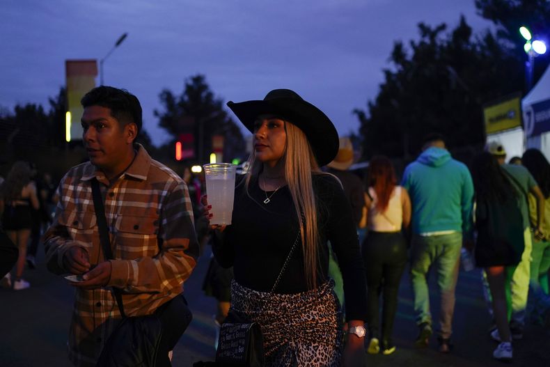 Una pareja camina cerca de un escenario en el festival Arre en la Ciudad de México el domingo 8 de septiembre de 2024. (Foto AP/Felix Marquez)