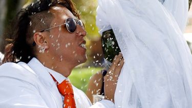 americateve | Enfundado en un traje blanco con corbata roja, Richard Torres, un joven medioambientalista, selló su amor con un árbol en un acto simbólico para exigir el cuidado de la naturaleza.