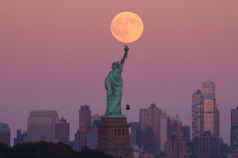 ARCHIVO - La Superluna sobre la Estatua de la Libertad y edificios de Brooklyn, el 6 de octubre de 2025, en Jersey City, Nueva Jersey. (AP Foto/Adam Gray)