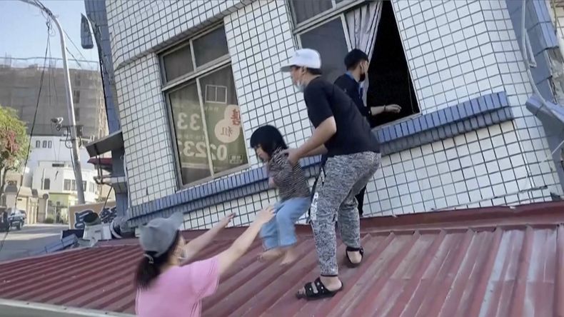 En esta imagen tomada de un video difundido por TVBS, residentes rescatan a un niño de un edificio parcialmente derrumbado en Hualien, al este de Taiwán, el miércoles 3 de abril de 2024. (TVBS via AP)
