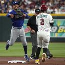 Mookie Betts, de los Dodgers de Los Ángeles, retira a Geraldo Perdomo, de los Diamondbacks de Arizona, con un batazo de Gabriel Moreno en la primera entrada del juego de béisbol de Grandes Ligas del domingo 9 de agosto de 2026, en Phoenix. (AP Foto/Rick Scuteri)