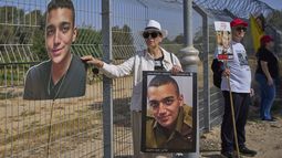 ARCHIVO - Varda Ben Baruch sostiene una foto de su nieto Edan Alexander, retenido como rehén en Gaza, junto a otros familiares que hablan por altoparlantes con la esperanza d que sus seres queridos les oigan, cerca de la frontera en Gaza en el kibbutz Nir Oz, en el sur de Israel, l 20 de abril de 2025. (AP Foto/Ohad Zwigenberg, Archivo)