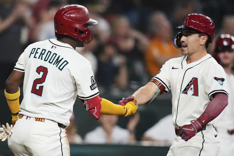 Corbin Carroll y el dominicano Geraldo Perdomo, de los Diamondbacks de Arizona, festejan luego que el primero conectó un jonrón ante los Orioles de Baltimore, el miércoles 9 de abril de 2025 (AP Foto/Ross D. Franklin)