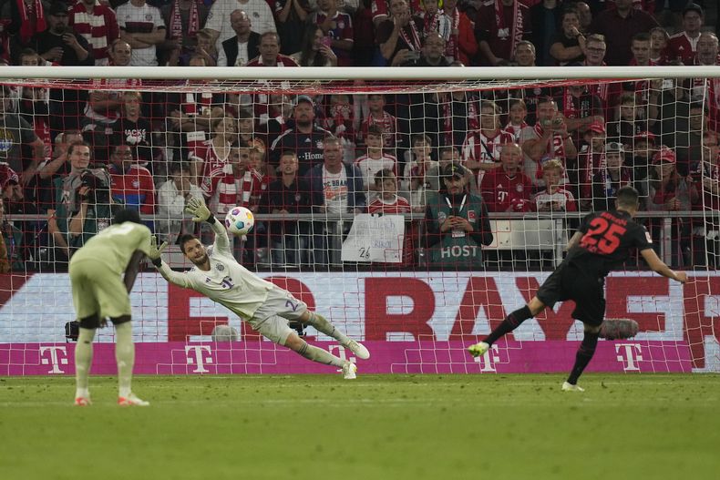 El argentino del Bayer Leverkusen Exequiel Palacios (derecha) anota un penalti para su equipo durante el partido de la Liga Alemana ante el Bayern Múnich en el Allianz Arena, en Múnich, Alemania. Viernes 15 de septiembre de 2023. (AP Foto/Matthias Schrader)