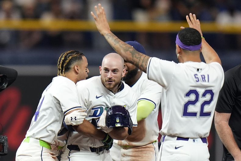 Brandon Lowe (centro), de los Rays de Tampa Bay, celebra tras conectar el sencillo que significó el triunfo sobre los Diamondbacks de Arizona, el viernes 16 de agosto de 2024 Fla. (AP Foto/Chris OMeara)