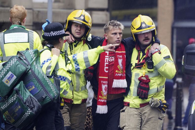 Policía y servicios de emergencia ayudan a una persona en el lugar del atropello en Water Street cerca del Liver Building en Liverpool el lunes 26 de mayo del 2025. (Owen Humphreys/PA via AP)