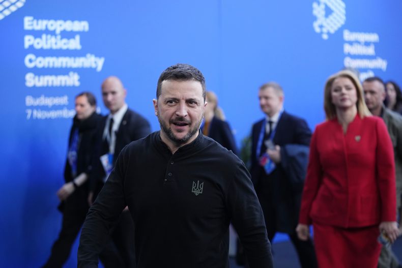 El presidente ucraniano, Volodymyr Zelenskyy, centro, y la primera ministra de Letonia, Evika Silina, derecha, llegan a la cumbre de la Comunidad Política Europea (EPC, por sus siglas en inglés) en la Puskas Arena de Budapest, Hungría, el jueves 7 de noviembre de 2024. (AP Foto/Petr Josek)