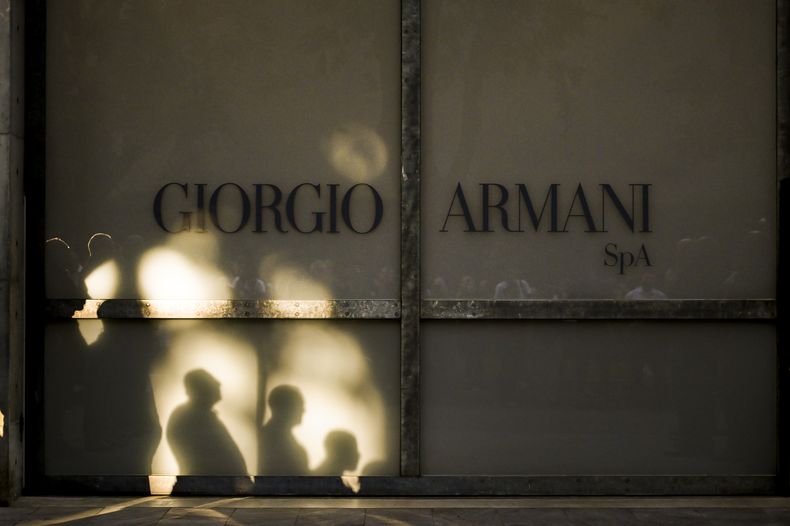 El personal de Giorgio Armani Spa se reúne afuera del Armani/Teatro en Milán, en el norte de Italia, mientras esperan el coche fúnebre con el ataúd del diseñador Giorgio Armani, quien falleció el jueves a los 91 años, el domingo 7 de septiembre de 2025. (Foto AP/Nicola Marfisi)