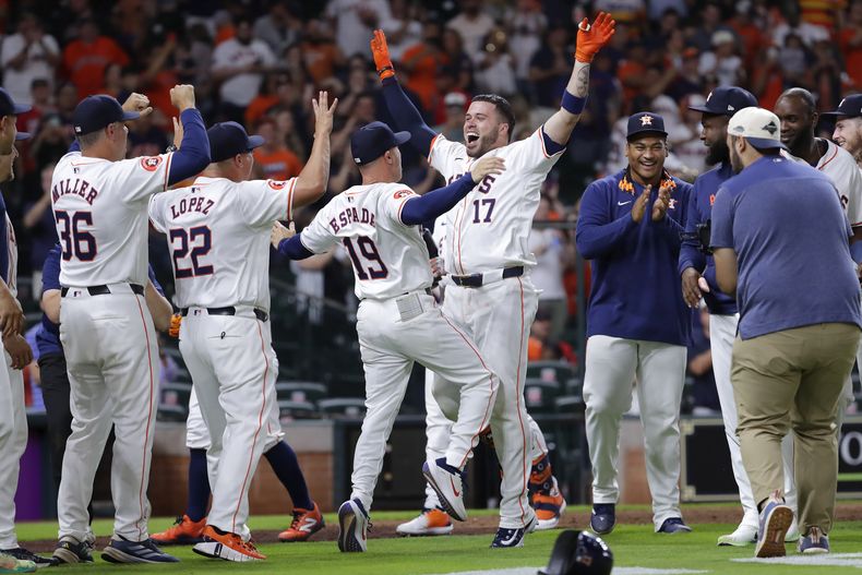 Victor Caratini de los Astros de Houston celebra su jonrón de la victoria con el mánager Joe Espada y sus compañeros ante los Guardianes de Cleveland el martes 30 de abril del 2024. (AP Foto/Michael Wyke)