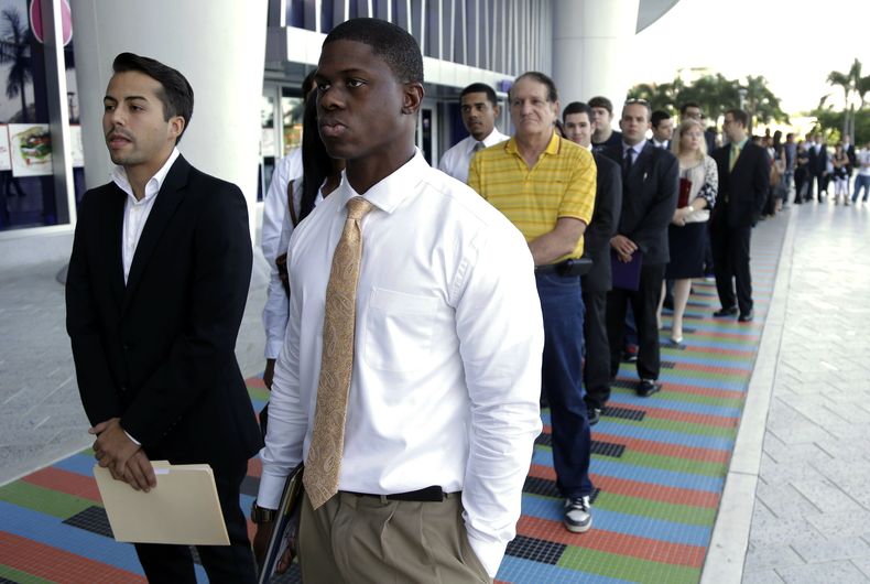 Luis M&eacute;ndez, de 23 a&ntilde;os, a la izquierda, y Maurice Mike, de 23, hacen fila durante una feria de empleo organizada por el equipo de b&eacute;isbol Marlins de Miami, en esa ciudad, el mi&eacute;rcoles 23 de octubre de 2013.