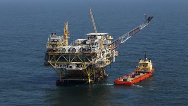 ARCHIVO - Esta foto de archivo del 10 de abril de 2011, muestra una plataforma y un buque de suministro en el Golfo de México, frente a la costa de Luisiana. El gobierno del presidente Joe Biden propuso el viernes hasta tres ventas de arrendamientos financieros de petróleo y gas en el Golfo de México, mientras intenta hacer malabares entre las empresas energéticas que quieren aumentar la producción de petróleo y gas y los activistas ecologistas que quieren que Biden detenga las nuevas perforaciones en alta mar en la lucha contra el cambio climático. (AP Foto/Gerald Herbert, Archivo)