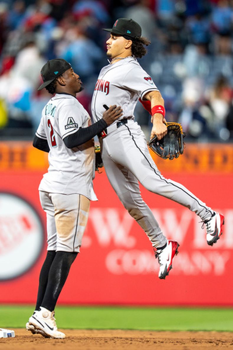 Alek Thomas, de los Diamondback de Arizona, salta hacia el dominicano Geraldo Perdomo para celebrar la victoria ante los Filis de Filadelfia, el viernes 10 de abril de 2026 (AP Foto/Chris Szagola)