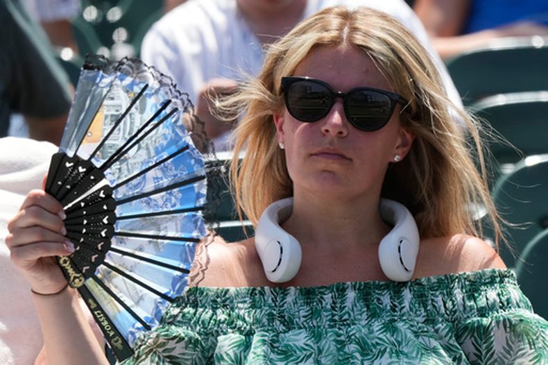 Una mujer trata de protegerse del calor en un estadio de béisbol en Chicago, el 1 de julio del 2026. (AP foto/Nam Y. Huh)