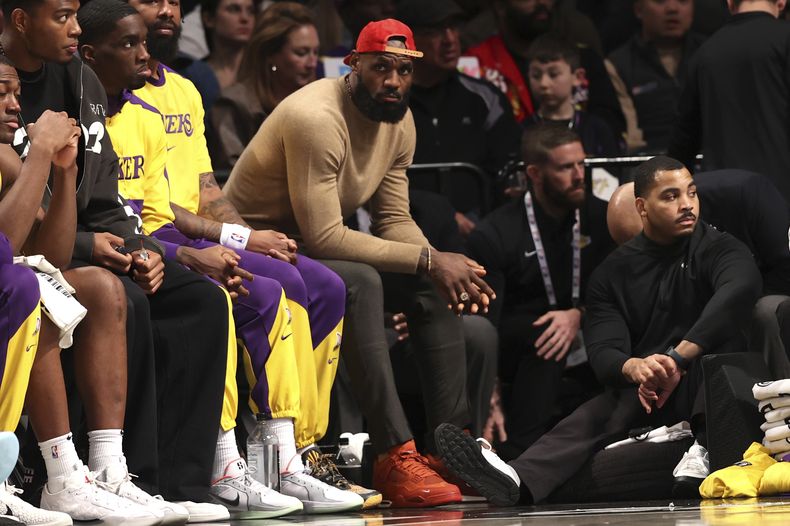 LeBron James, centro, de los Lakers de Los Ángeles, se sienta en el banquillo durante la segunda mitad de un partido de baloncesto de la NBA contra los Nets de Brooklyn, el lunes 10 de marzo de 2025, en Nueva York. (AP Foto/Pamela Smith)