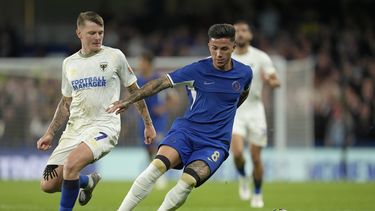 El argentino Enzo Fernandez del Chelsea pelea por el balón James Tilley del Wimbledon en el encuentro de la Copa de Liga el miércoles 30 de agosto del 2023. (AP Foto/Kin Cheung)