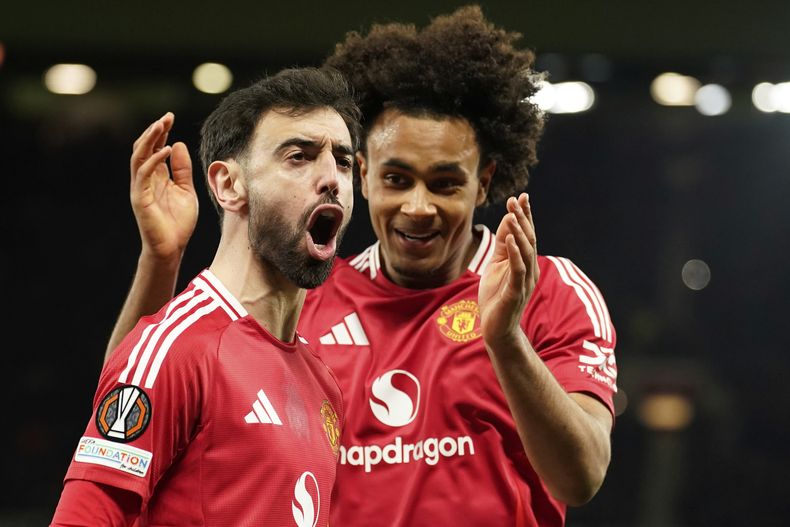 Bruno Fernandes, del Manchester United, a la izquierda, y Joshua Zirkzee, del Manchester United, celebran el primer gol de su equipo durante el partido de fútbol de la Liga Europa entre el Manchester United y la Real Sociedad en el estadio Old Trafford en Manchester, Inglaterra, el jueves 13 de marzo de 2025. (AP Foto/Dave Thompson)