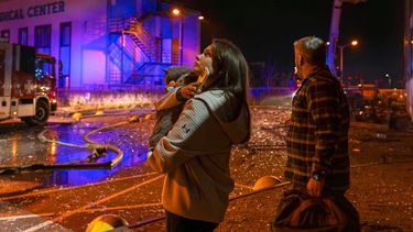 Personas observan cómo socorristas trabajan para extinguir un incendio tras un ataque ruso en Kiev, Ucrania, el martes 25 de noviembre de 2025. (AP Foto/Dan Bashakov)