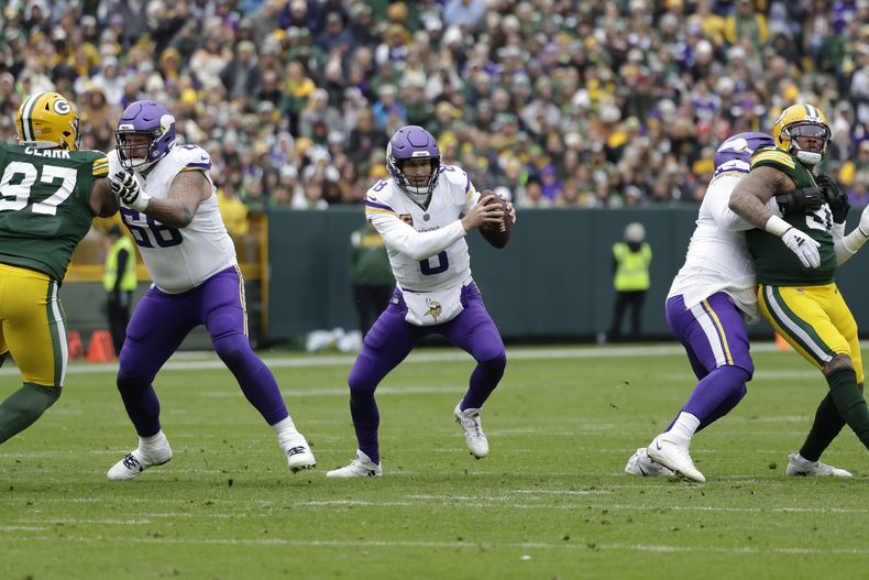 Kirk Cousins (8), quarterback de los Vikings de Minnesota, sujeta el ovoide y busca evitar la presión de los defensivos durante la segunda mitad del partido de la NFL en contra de los Packers de Green Bay, el domingo 29 de octubre de 2023. en Green Bay, Wisconsin. Cousins resultó lesionado durante la jugada. Fue operado del tendón de Aquiles el miércoles 1 de noviembre de 2023.. (AP Foto/Matt Ludtke)