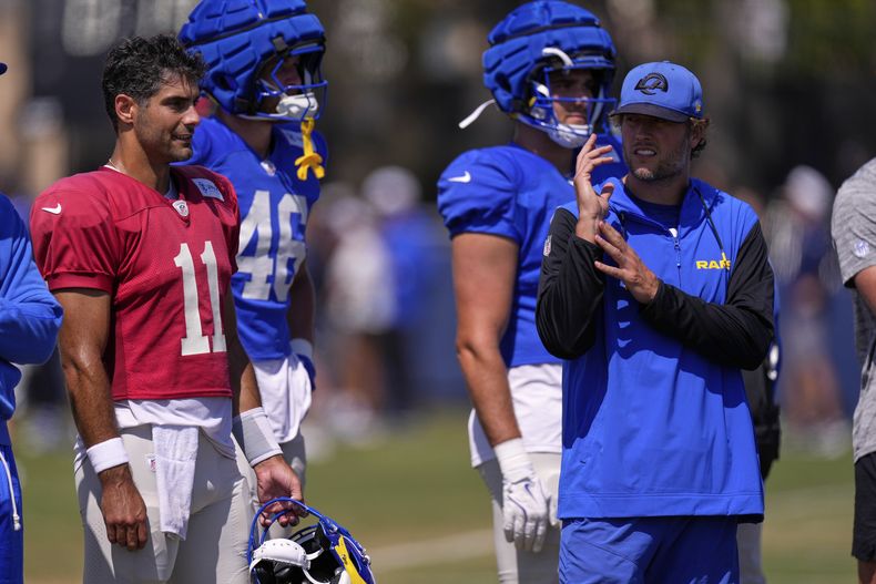 Jimmy Garoppolo, izquierda, quarterback de los Rams de Los Ángeles, habla con su compañero de posición, Matthew Stafford, derecha, el titular del equipo, durante un partido de práctica durante el campamento de entrenamiento frente a los Cowboys de Dallas, el martes 5 de agosto de 2025, en Oxnard, California. (AP Foto/Mark J. Terrill)