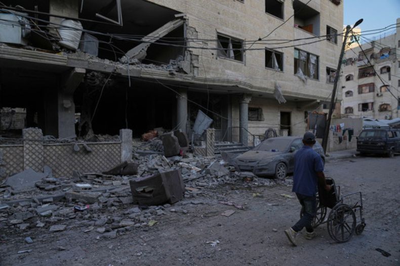 Palestinos inspeccionan el lugar donde se produjo un ataque aéreos israelí de madrugada, en la ciudad de Gaza, el 3 de octubre de 2026. (AP Foto/Jehad Alshrafi)