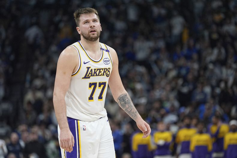 ARCHIVO - El base de los Lakers de Los Ángeles, Luka Doncic (77), reacciona después de una falta pitada a los Lakers durante la primera mitad del cuarto partido de una serie de playoffs de primera ronda de la NBA contra los Timberwolves de Minnesota, el domingo 27 de abril de 2025, en Mineápolis. (AP Photo/Abbie Parr, Archivo)