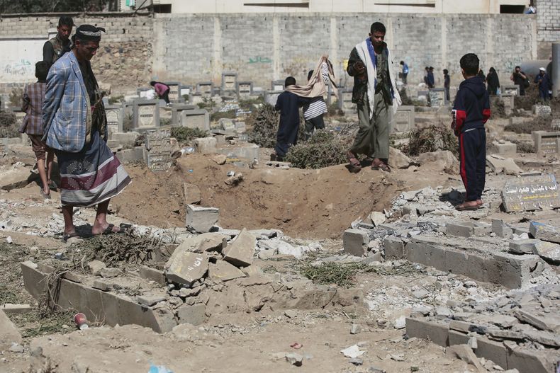 Yemeníes observan un agujero en el cementerio Magel Al Dammah al día siguiente de que fue alcanzado por ataques estadounidenses, el domingo 20 de abril de 2025, en Saná, Yemen. (AP Foto)