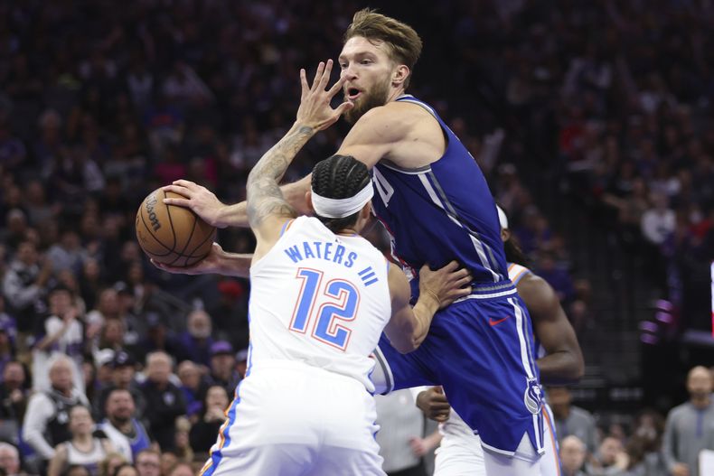 Domantas Sabonis, de los Kings de Sacramento, avanza a la cesta frente a Lindy Waters, del Thunder de Oklahoma City, el viernes 10 de noviembre de 2023 (AP Foto/Jed Jacobsohn)