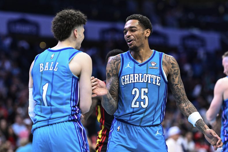 P.J. Washington y LaMelo Ball, de los Hornets de Charlotte, celebran la victoria sobre los Hawks de Atlanta, el miércoles 25 de octubre de 2023 (AP Foto/Matt Kelley)