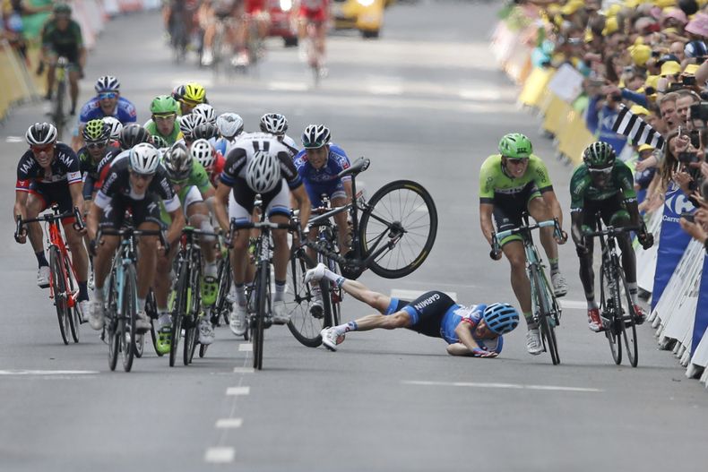 Andrew Talansky de Estados Unidos se cae mientras el italiano Matteo Trentin est&aacute; por ganar la s&eacute;ptima etapa del Tour de francia en Nancy el 11 de julio del 2014. (AP Foto/Peter Dejong)