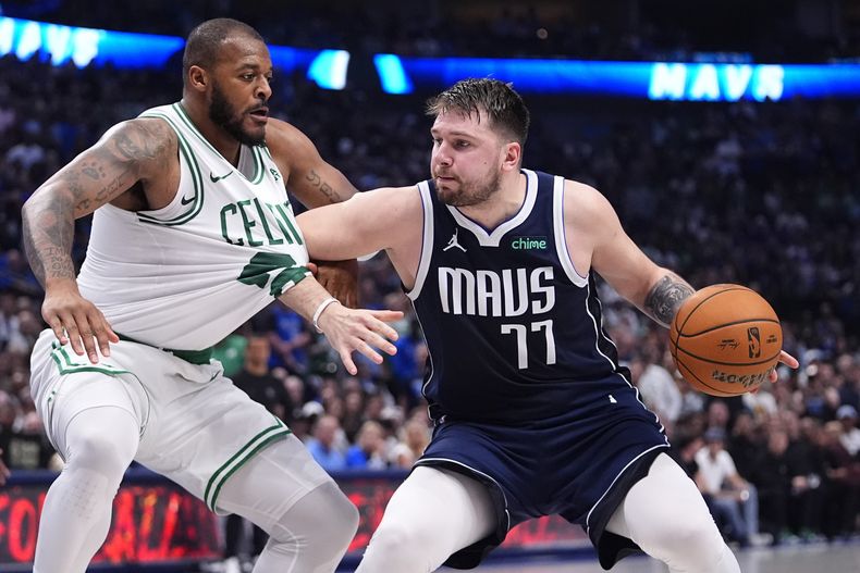El base de los Mavericks de Dallas Luka Doncic intenta avanzar con el balón mientras lo defiende el alero de los Celtics de Boston Xavier Tillman en el juego 4 de las Finales de la NBA el 14 de junio del 2024. (AP Foto/Julio Cortez)
