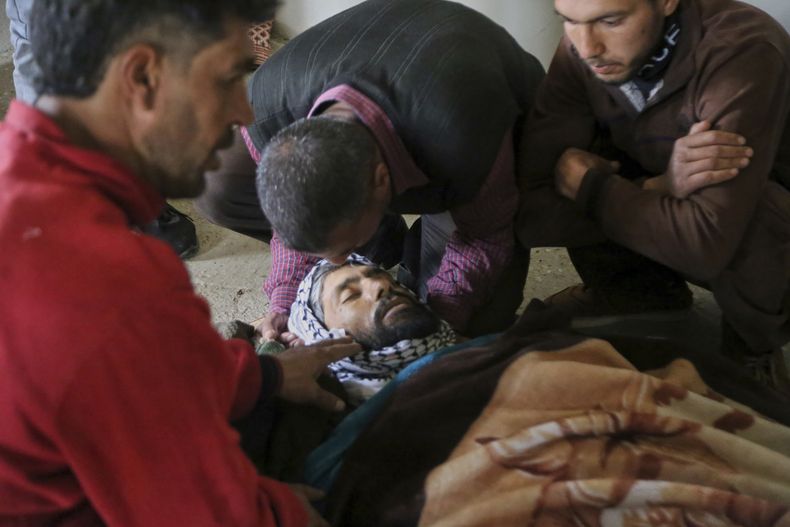 Varios residentes lloran ante el cuerpo de Ayman Salem al-Suleiman, muerto presuntamente en un ataque israelí con drones que cobró al menos cuatro vidas, en Koayiah, en el suroeste de Siria, el martes 25 de marzo de 2025. (AP Foto/Malek Khattab)