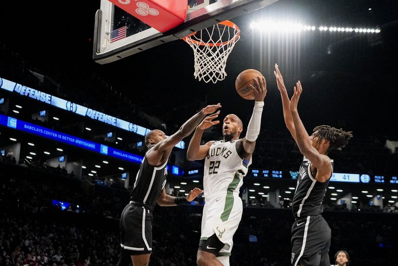 Khris Middleton, alero de los Bucks de Milwaukee, dispara frente a Dariq Whitehead, de los Nets de Brooklyn, en el partido del miércoles 27 de diciembre de 2023 (AP Foto/Peter K. Afriyie)