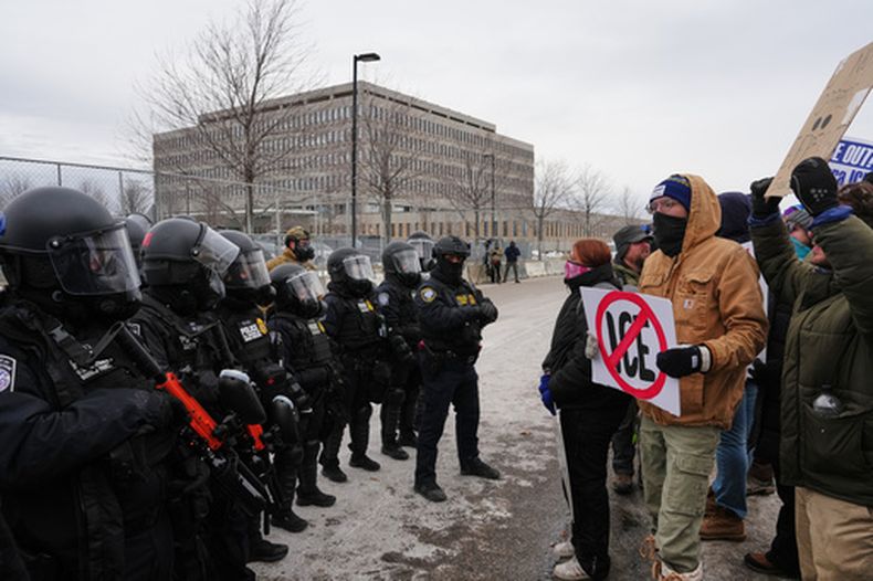 Agentes federales de inmigración se enfrentan a manifestantes frente al edificio federal Bishop Henry Whipple, en Minneapolis, el jueves 15 de enero de 2026. (AP Foto/Adam Gray)