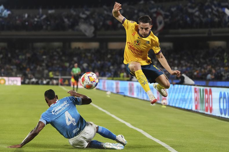 Willer Ditta, del Cruz Azul, se barre frente a Álvaro Fidalgo, del América, en la ida de las semifinales del fútbol mexicano, el jueves 15 de mayo de 2025 (AP Foto/Eduardo Verdugo)