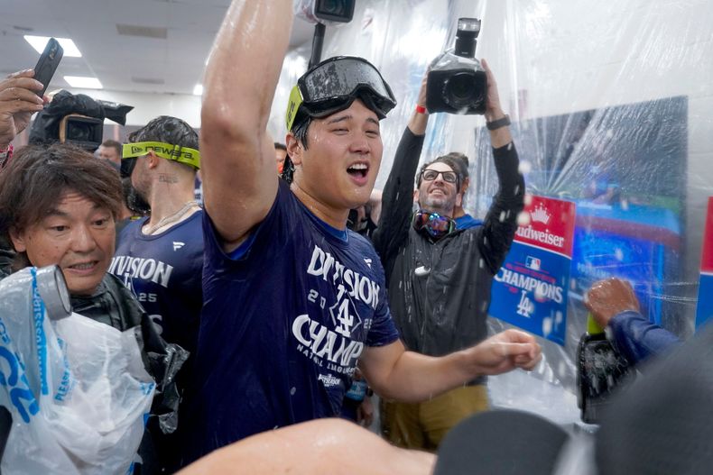 Shohei Ohtani de los Dodgers de Los Ángeles celebra la conquista del título de la División Oeste de la Liga Nacional, el jueves 25 de septiembre de 2025, en Phoenix. (AP Foto/Darryl Webb)