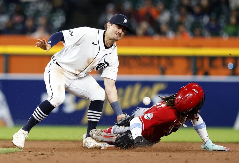 Zach McKinstry, campocorto de los Tigres de Detroit, pierde la pelota mientras intenta retirar al dominicano Elly de la Cruz, quien logró el robo por los Rojos de Cincinnati el miércoles 13 de septiembre de 2023 (AP Foto/Duane Burleson)