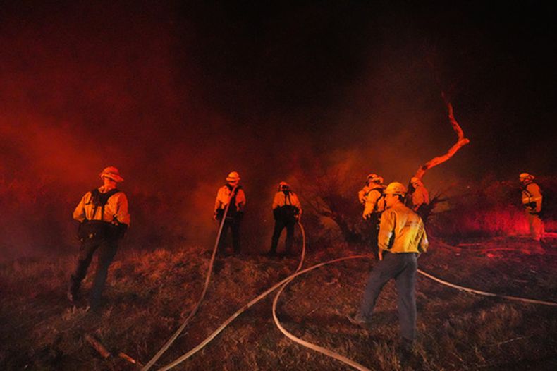 Equipos de bomberos toman posición frente al incendio Bryson el jueves 15 de octubre de 2026, en Malibu, California. (AP Foto/Jae C. Hong)