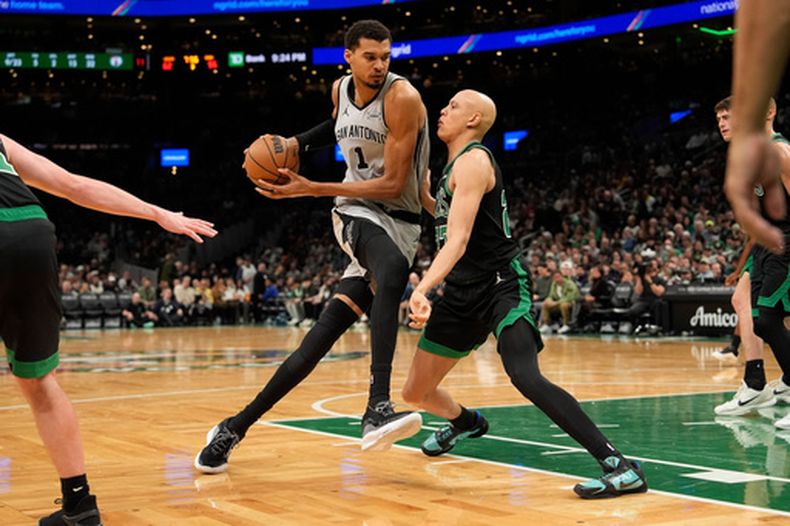 Victor Wembanyama (1), alero de los Spurs de San Antonio, avanza hacia la canasta contra Derrick White (9), base de los Celtics de Boston, durante la segunda mitad de un partido de baloncesto de la NBA, el sábado 10 de enero de 2026, en Boston. (AP Photo/Robert F. Bukaty)