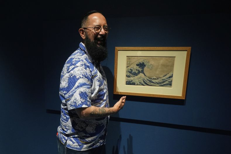 El periodista de televisión mexicana Álvaro Cueva posa junto a una xilografía del japonés Hokusai titulada La gran ola de Kanagawa, durante la inauguración de la exposición Japón: del mito al manga, en el Museo Franz Mayer, en la Ciudad de México, el jueves 7 de agosto de 2025. (Foto AP/Fernando Llano)