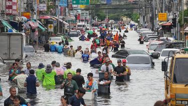 Personas caminan por una calle inundada tras fuertes lluvias en Bangkok, Tailandia, el lunes 28 de septiembre de 2026. (AP Foto/Sakchai Lalit)