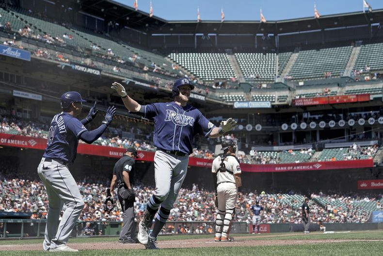 Luke Raley (centro), de los Rays de Tampa Bay, festeja con el panameño Christian Bethancourt, luego de conectar un jonrón de campo el miércoles 16 de agosto de 2023 ante los Gigantes de San Francisco (AP Foto/Godofredo A. Vásquez)