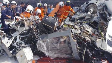 En esta imagen, distribuida por el Departamento de Bomberos y Rescate de Malasia, varios operarios inspeccionan el lugar donde se estrellaron dos helicópteros militares, en Lumur, en el estado de Perak, el 23 de abril de 2024. (Terence Tan/Ministerio de Comunicación e Información vía AP)