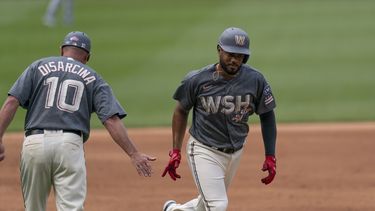 Jeimer Candelario de los Nacionales de Washington celebra con el entrenador de tercera base Gary Disarcina tras pegar un jonrón en la primera entrada en el juego ante los Rangers de Texas el sábado 8 de julio del 2023. (AP Foto/Stephanie Scarbrough)