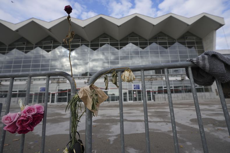 Flores colocadas ante una estación d tren donde se derrumbó parte de una cornisa un mes antes, en Novi Sad, Serbia, el domingo 1 de diciembre de 2024. (AP Foto/Darko Vojinovic)