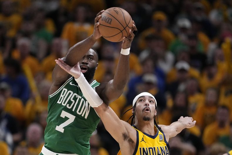 Jaylen Brown (7), de los Celtics de Boston, atrapa un pase sobre Andrew Nembhard, de los Pacers de Indiana, durante la segunda mitad del juego de baloncesto de la NBA, en el Juego 4 de las Finales de la Conferencia Este, el lunes 27 de mayo de 2024, en Indianápolis. (AP Foto/Michael Conroy)