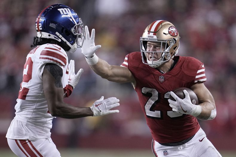 Christian McCaffrey, corredor de los 49ers de San Francisco, realiza un acarreo ante Adoree Jackson, cornerback de los Giants de Nueva York, el jueves 21 de septiembre de 2023 (AP Foto/Godofredo A. Vásquez)