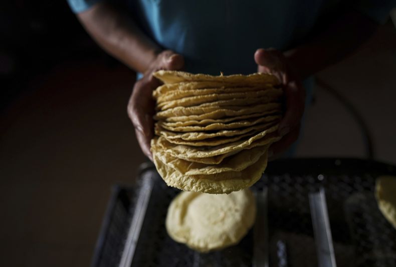 ARCHIVO - Un trabajador empaca tortillas para venderlas en una tortillería de la Ciudad de México, el 9 de mayo de 2022. (AP Foto/Fernando Llano, Archivo)