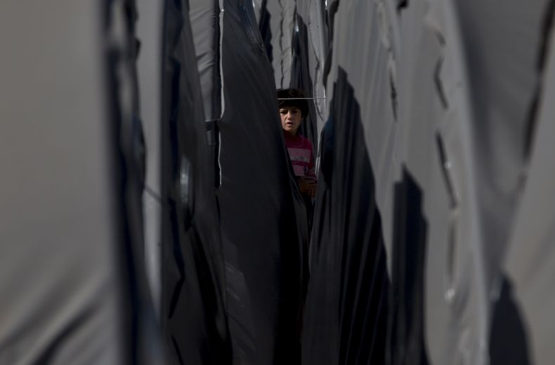 Un ni&ntilde;o curdo sirio refugiado de Kobani camina entre tiendas en un campo de refugiados de Suruc, cerca de la frontera entre Turqu&iacute;a y Siria, el 3 de noviembre de 2014.  (AP Foto/Vadim Ghirda)
