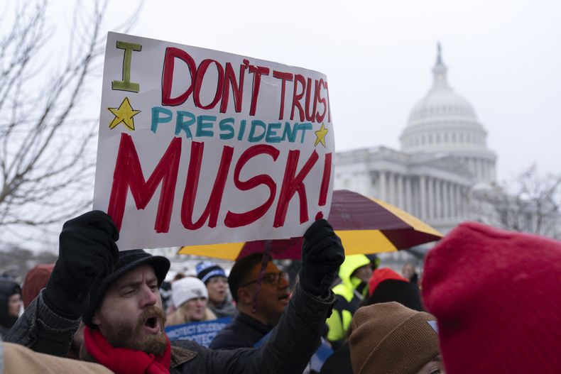 Varias personas protestan contra las políticas del presidente Donald Trump y del multimillonario Elon Musk frente al Capitolio federal en Washington, el miércoles 12 de febrero de 2025. (AP Foto/Jose Luis Magana)