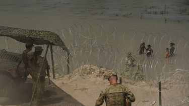 ARCHIVO - Guardias observan mientras migrantes tratan de cruzar el río Bravo (o Grande) desde México hacia Estados Unidos, el 11 de julio de 2023, cerca de Eagle Pass, Texas. (AP Foto/Eric Gay, archivo)